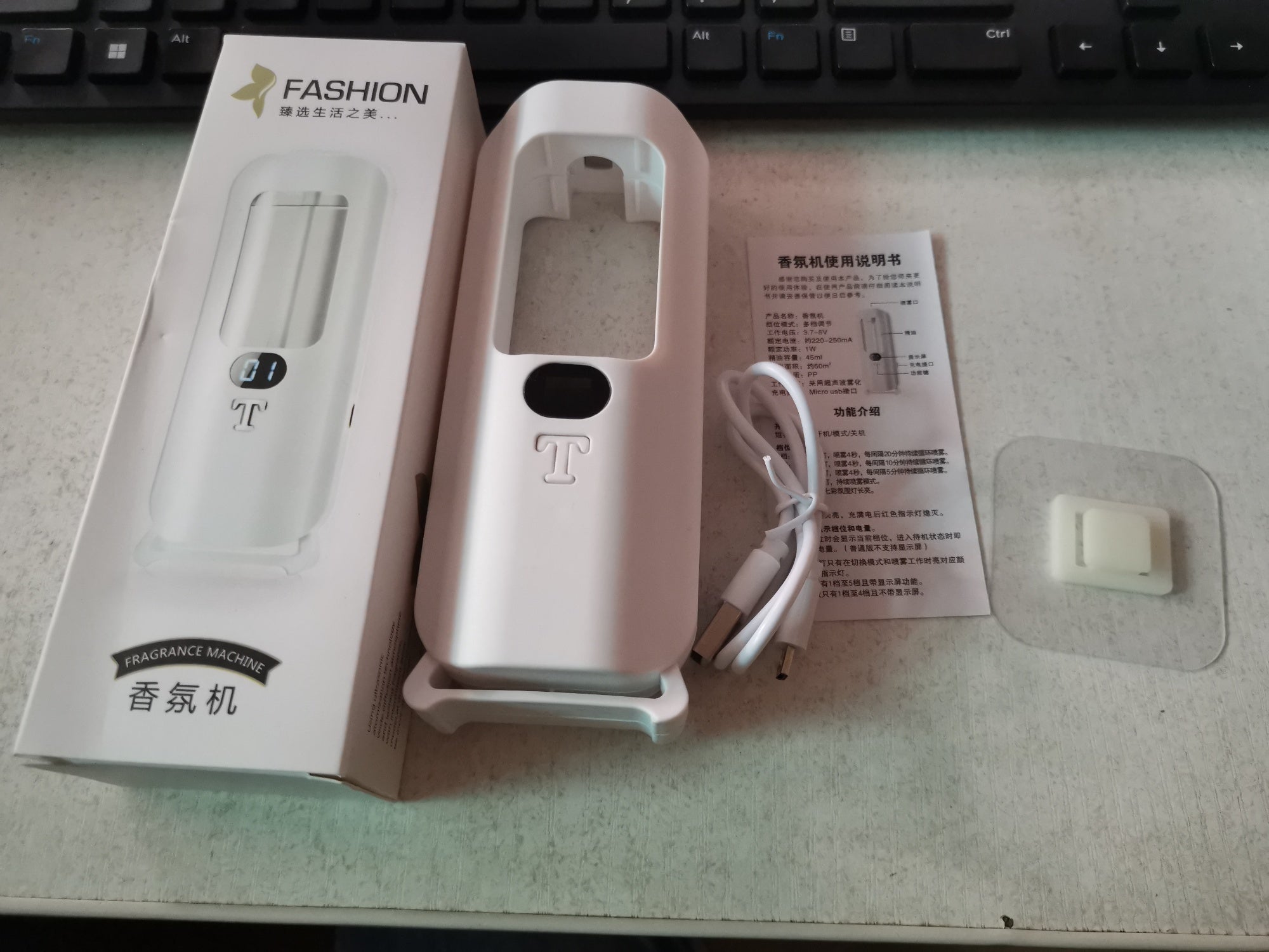 White electronic device with packaging and user manual on a desk