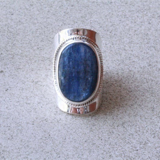 Silver ring with a blue stone on a gray background