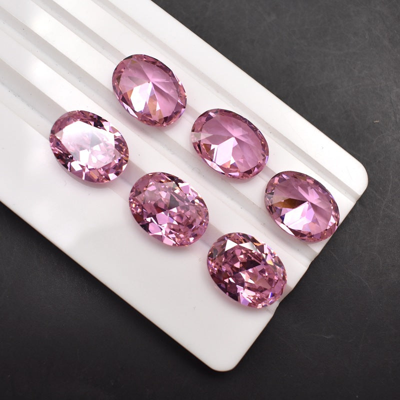 Pink gemstones on a white tray against a dark background