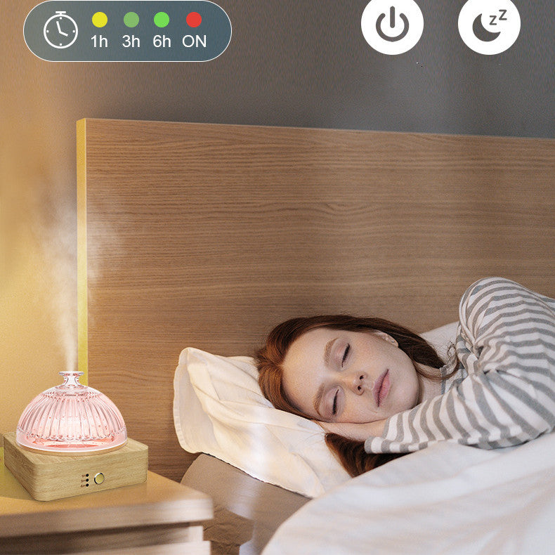 Woman sleeping in bed with a night light on a wooden nightstand.