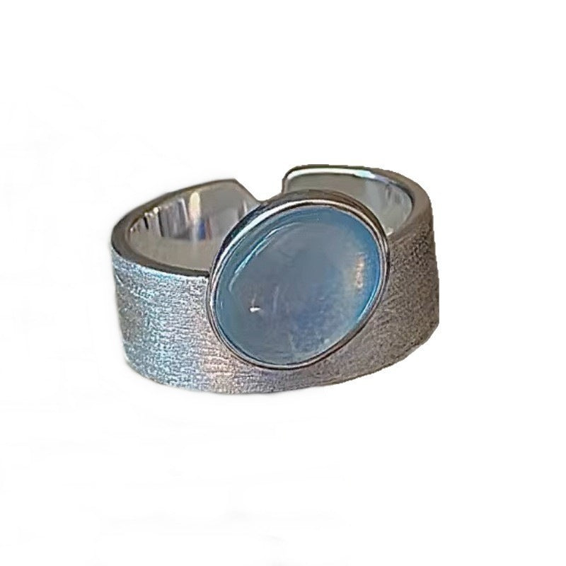 Silver ring with a blue stone on a white background