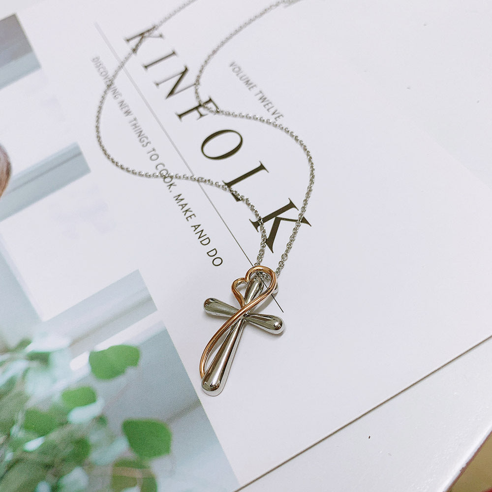 Cross-shaped necklace on a magazine with visible text