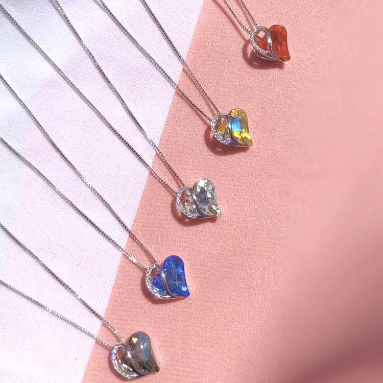 Heart-shaped pendants on silver necklaces against a pink background