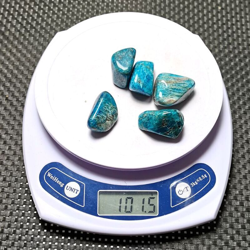 Turquoise stones on a digital scale with a gray textured background