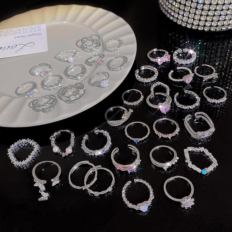 Collection of silver hoop earrings on a dark surface with a white plate in the background.