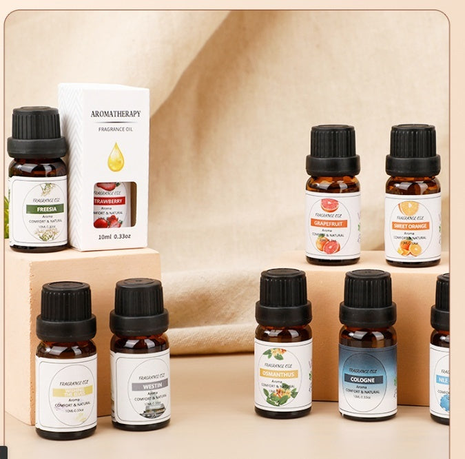 Collection of essential oil bottles with labels on a wooden surface