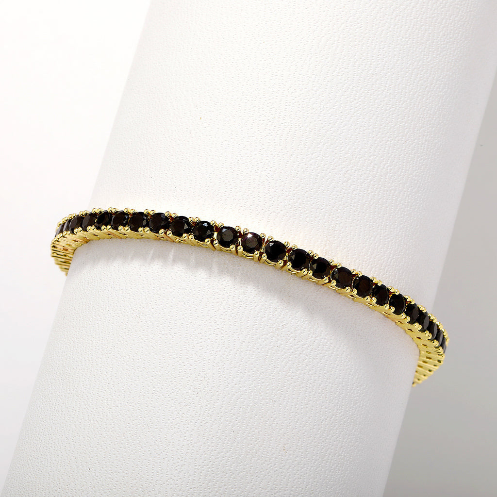 Gold bracelet with black stones on a white mannequin arm