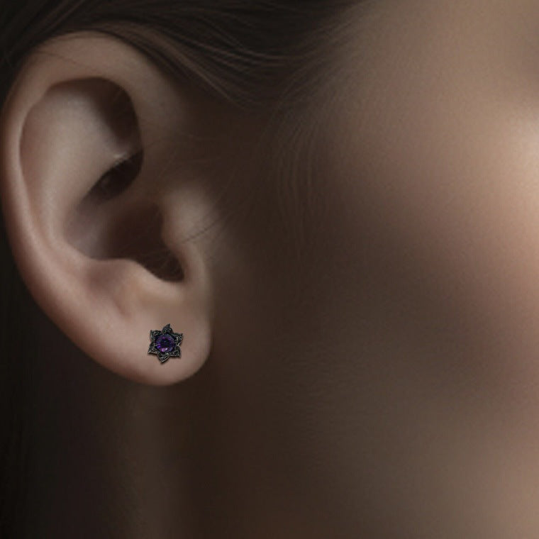 Close-up of an ear with a decorative stud earring on a neutral background