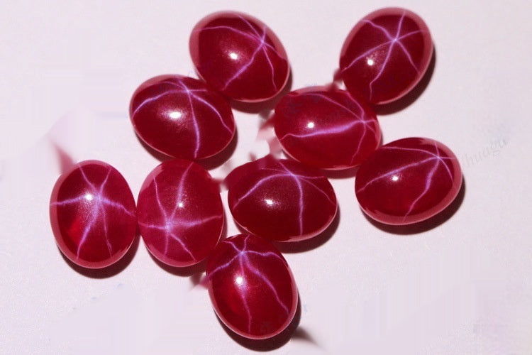 Red gemstones with star-like patterns on a white background