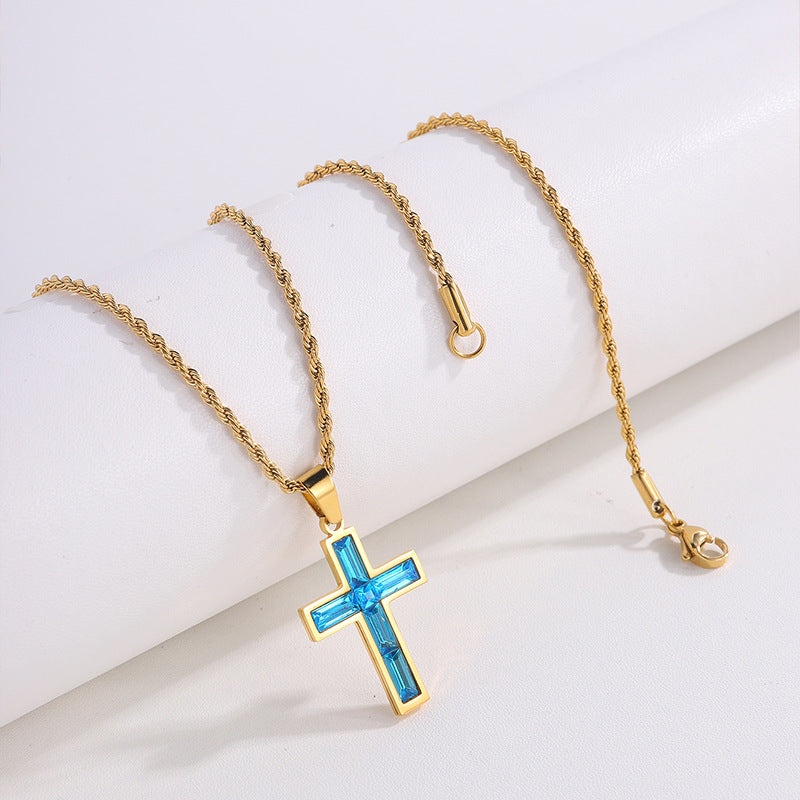 Gold necklace with a blue cross pendant on a white background