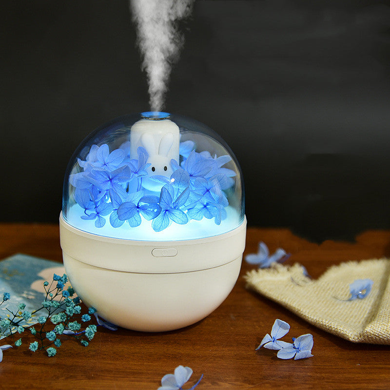 Humidifier with blue flowers inside on a wooden surface