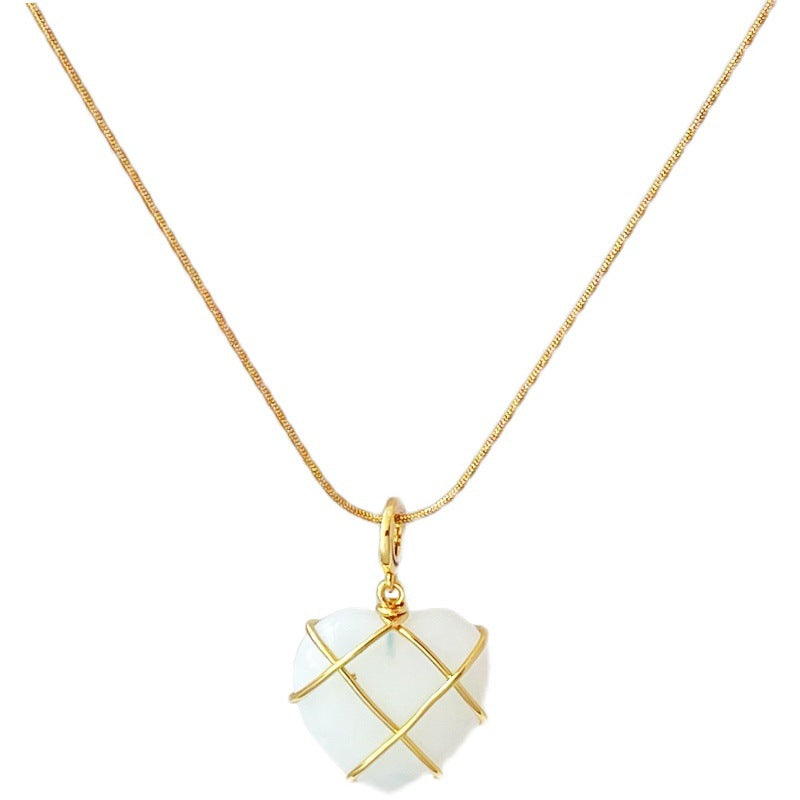 Heart-shaped pendant with gold accents on a gold chain against a white background